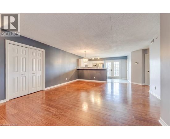 A spacious room with wooden floors and a large window.