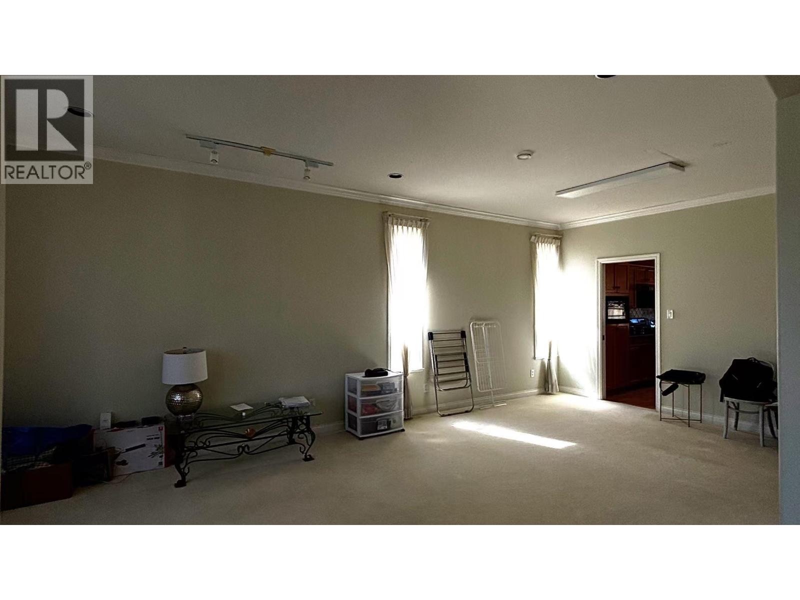 A room with a ladder and a table with a lamp on it.