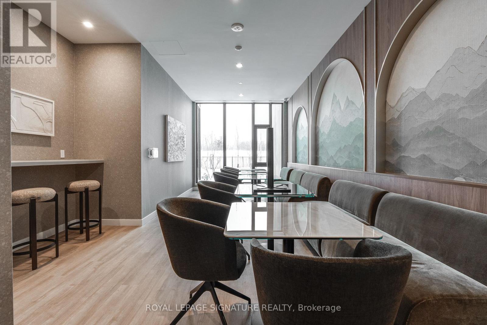 A modern dining room with a glass table and chairs.