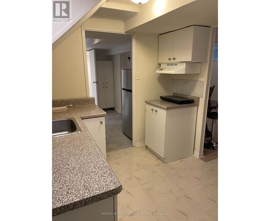 A kitchen with a granite counter top and white cabinets.