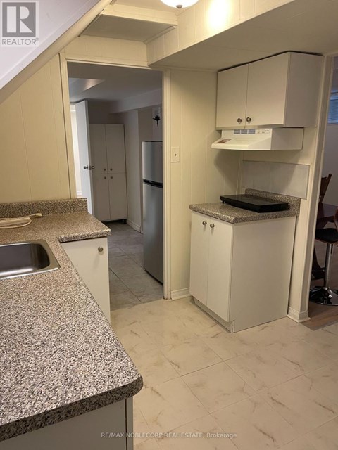A kitchen with a granite counter top and white cabinets.