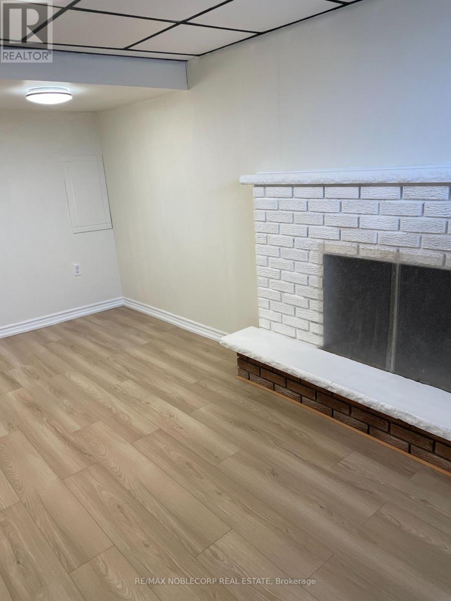 A room with a fireplace and wooden flooring.