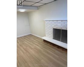 A room with a fireplace and wooden flooring.