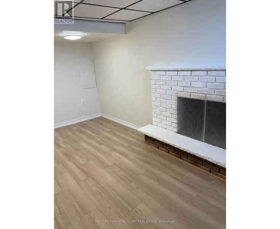 A room with a fireplace and wooden flooring.