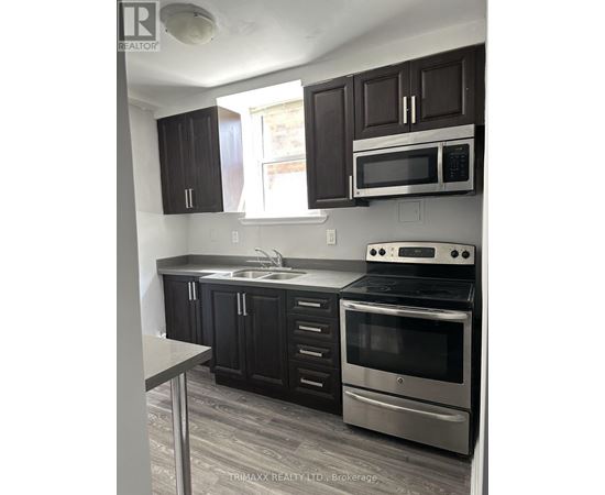 A kitchen with black cabinets and stainless steel appliances.