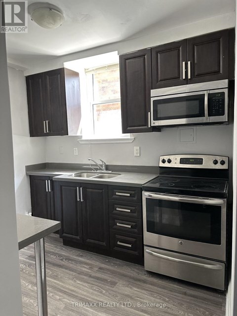 A kitchen with black cabinets and stainless steel appliances.