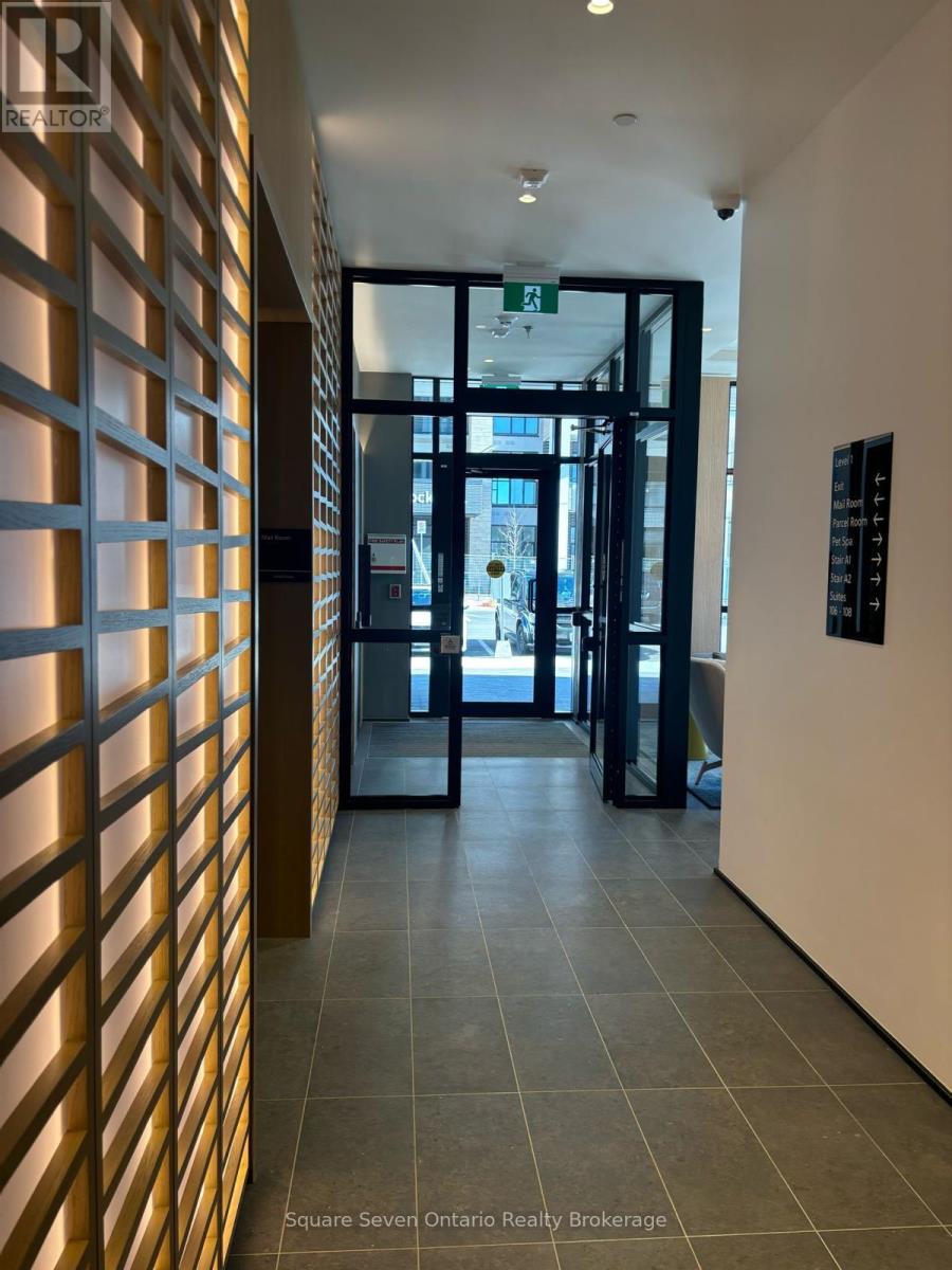 A hallway with a wooden wall on the left and a glass door on the right.