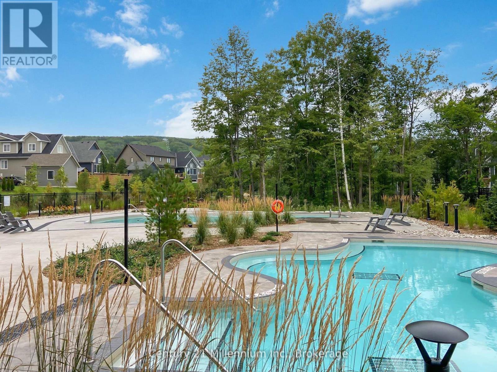 A pool surrounded by trees and a hillside.