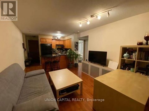 A living room with a grey couch and a wooden coffee table.