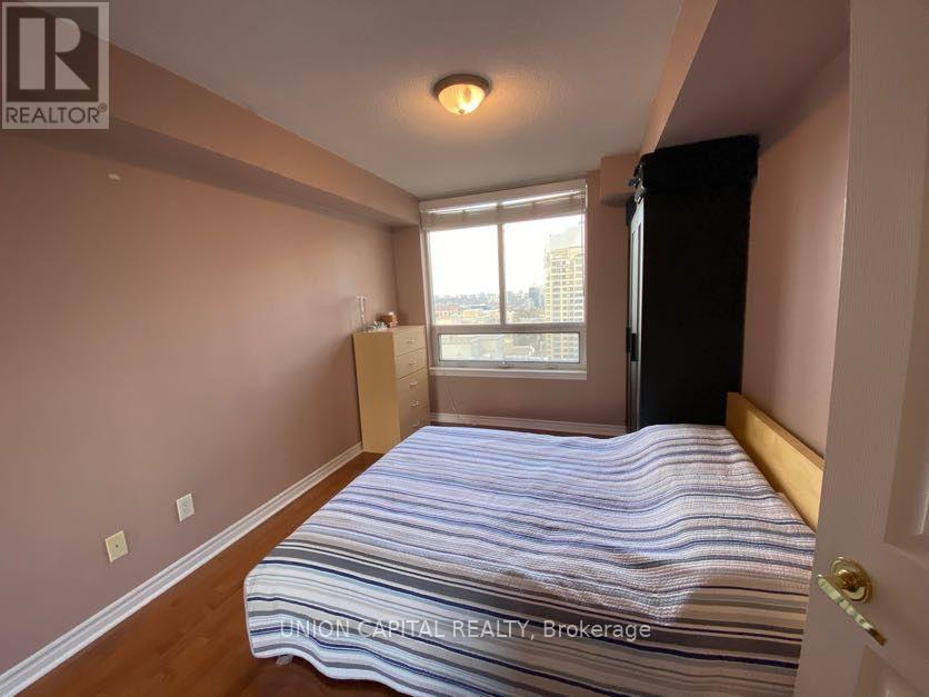 A bedroom with a bed, dresser, and window.