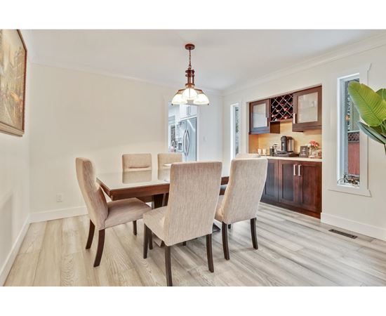 A dining room with a table and chairs.