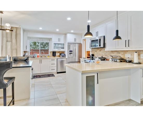 A modern kitchen with white cabinets and a large island.