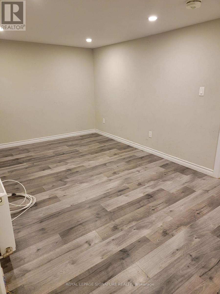 A room with wooden flooring and a white wall.