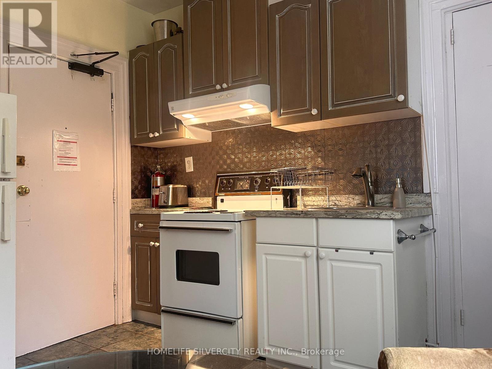 A kitchen with a white oven and brown cabinets.