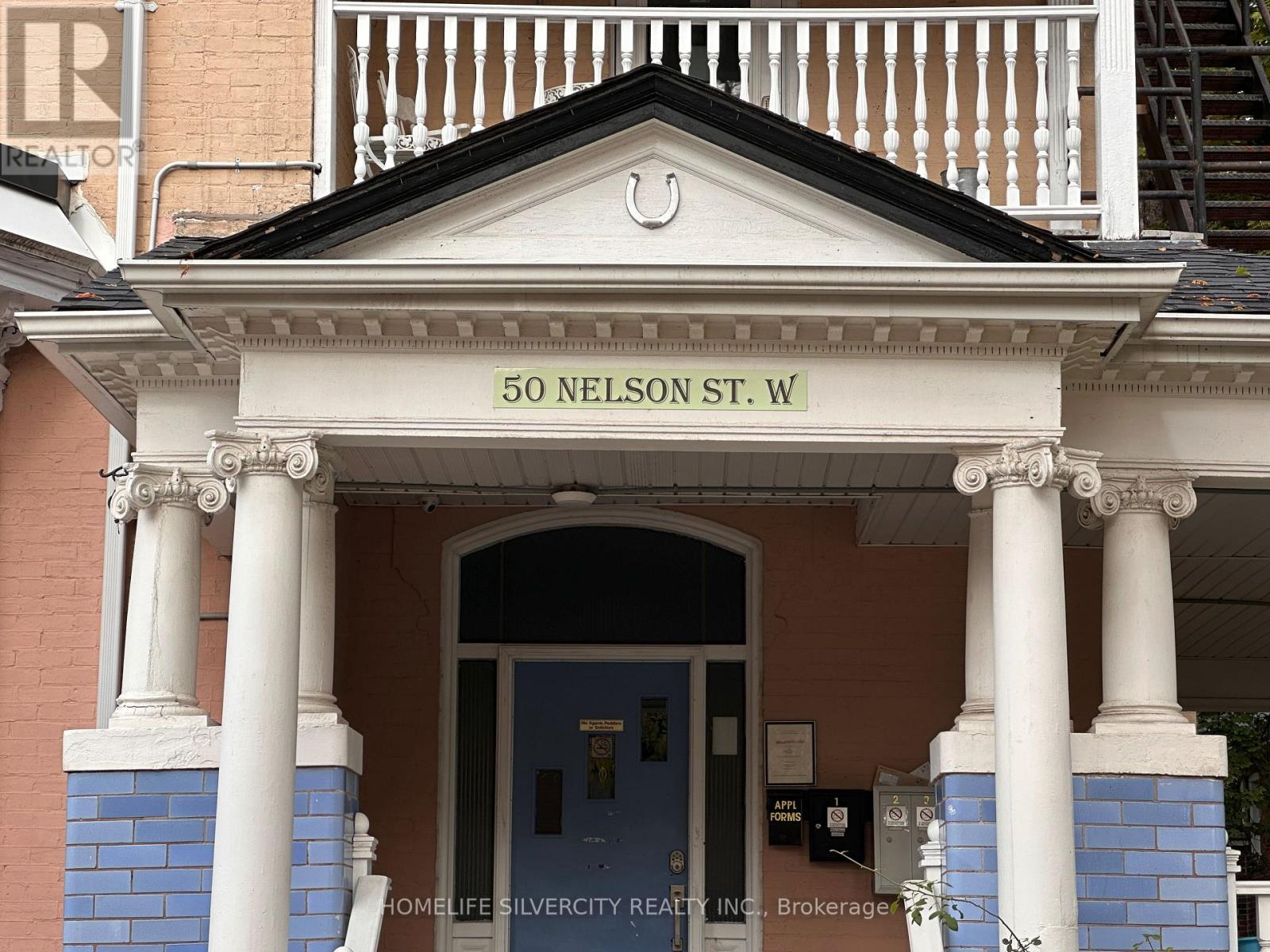The front of a building with a blue door and pillars.