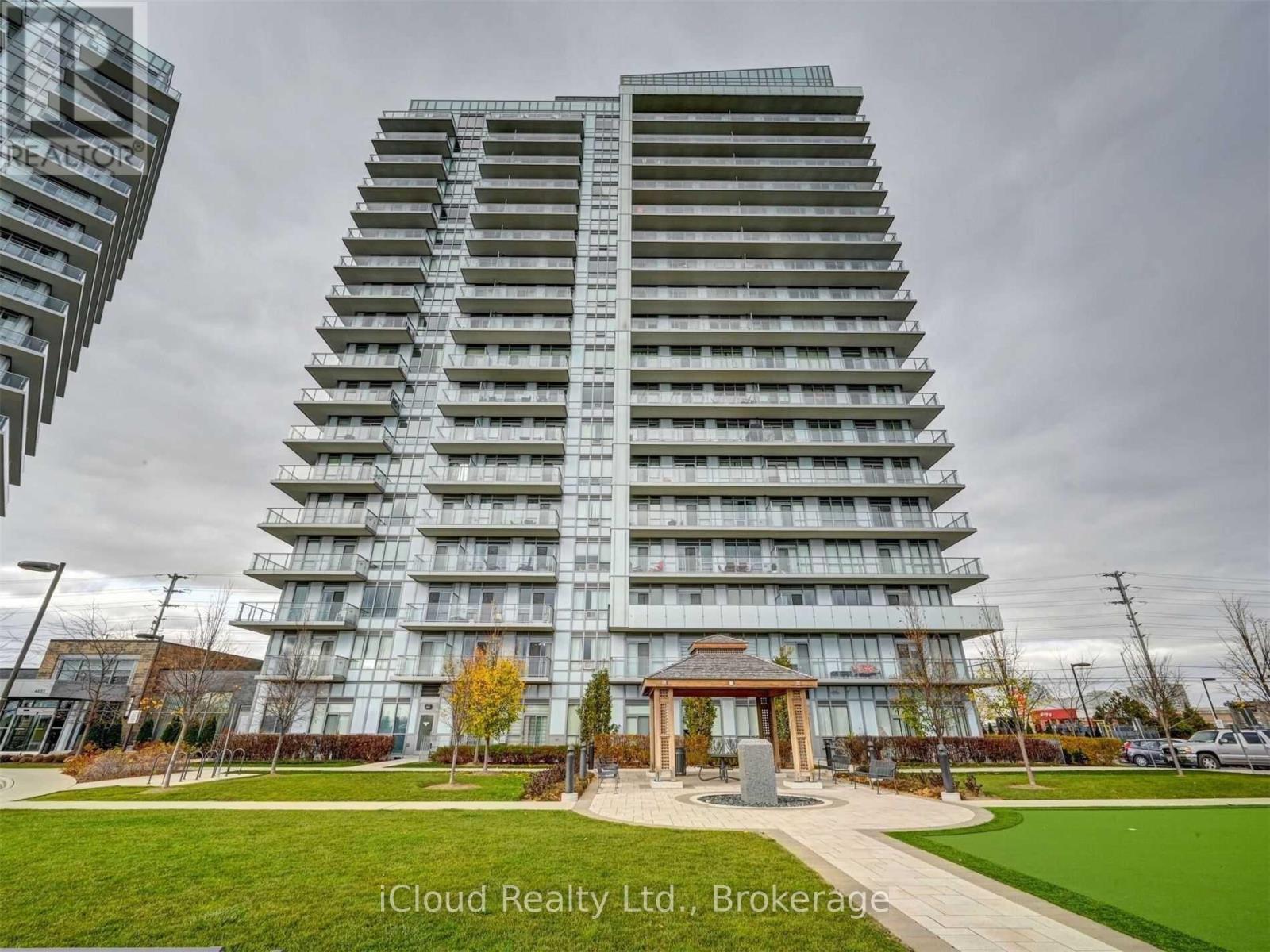 A tall residential building with a gazebo-like structure in front.
