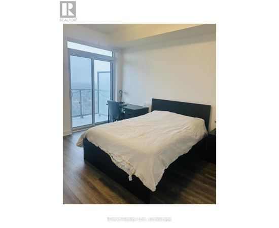 A bedroom with a large bed and a balcony.