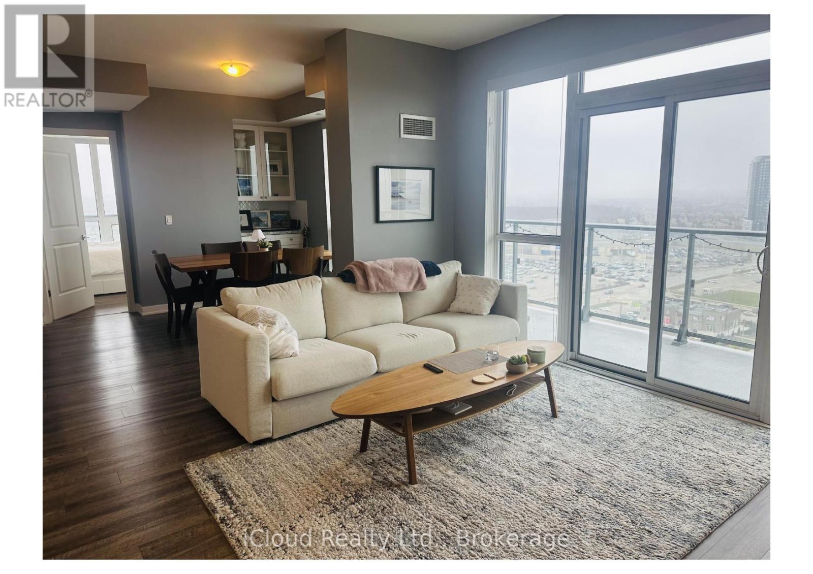 A living room with a couch, coffee table, and sliding glass doors.