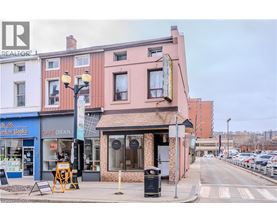 A street view with a cafe and a realtor sign.