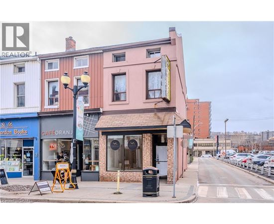 A street view with a cafe and a realtor sign.