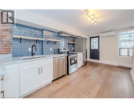 A kitchen with white cabinets and a blue backsplash.