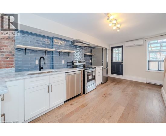 A kitchen with white cabinets and a blue backsplash.