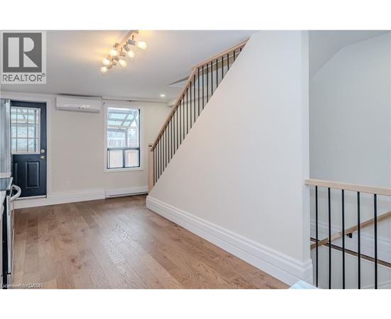 A spacious room with a staircase leading to the upper floor.