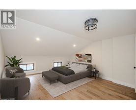 A bedroom with a bed, chair, and rug.