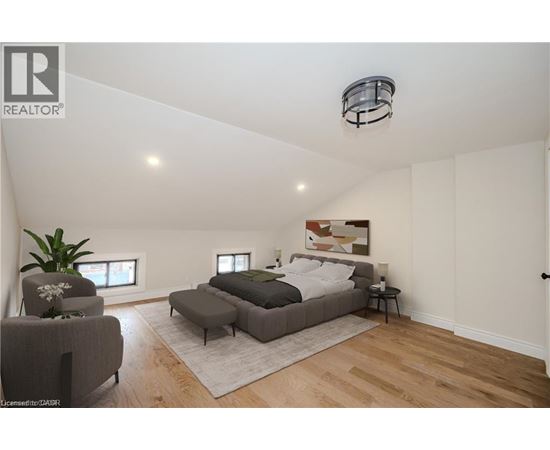 A bedroom with a bed, chair, and rug.