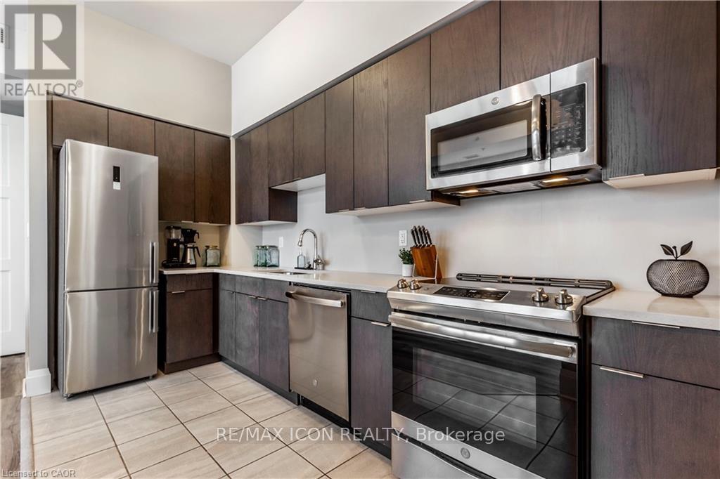 A modern kitchen with dark wood cabinets and stainless steel appliances.