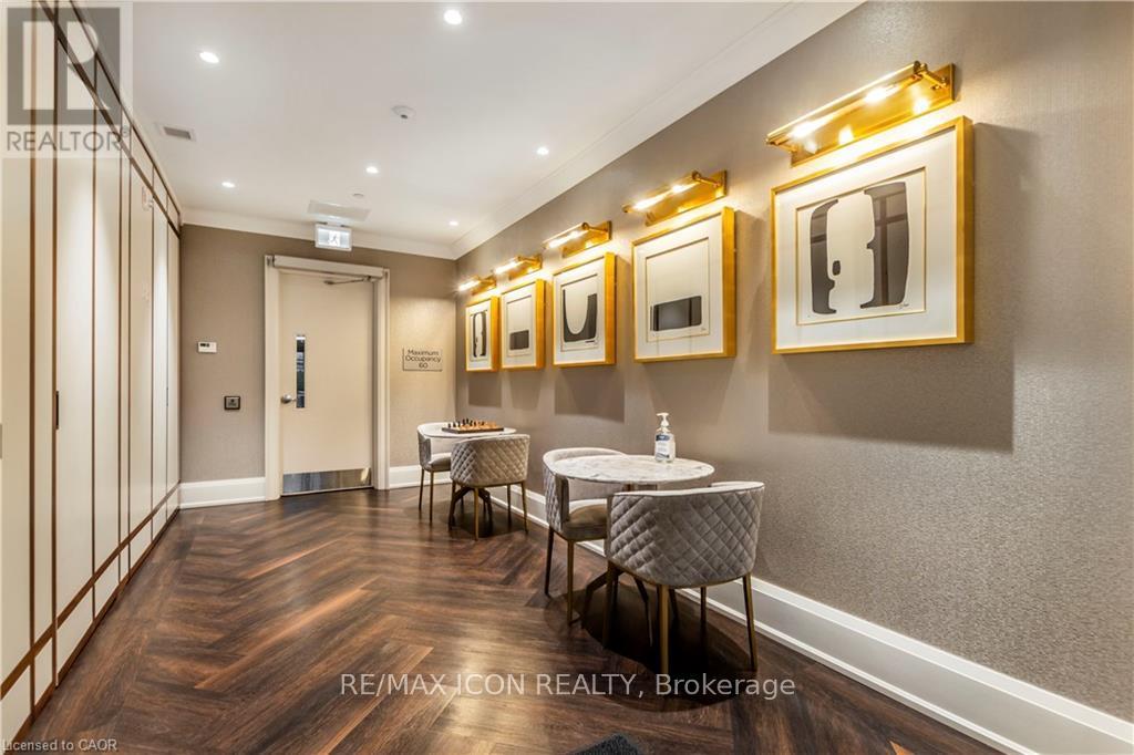 A dining room with a table set for two and framed pictures on the wall.