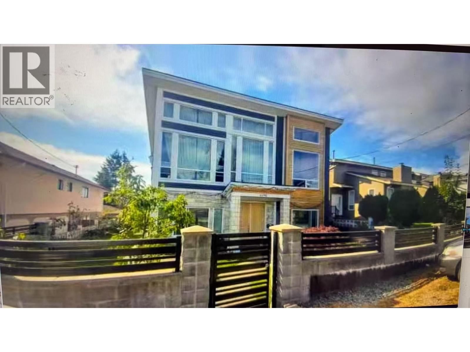 A modern house with a large front yard is for sale.