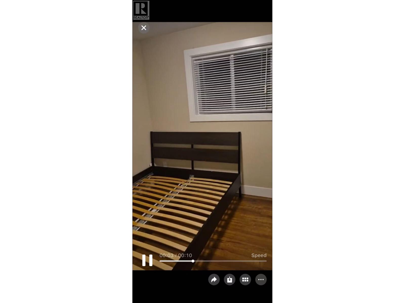 A bed with a striped bedspread is in the center of the image.