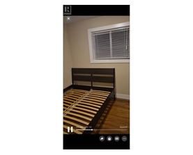 A bed with a striped bedspread is in the center of the image.
