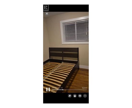 A bed with a striped bedspread is in the center of the image.