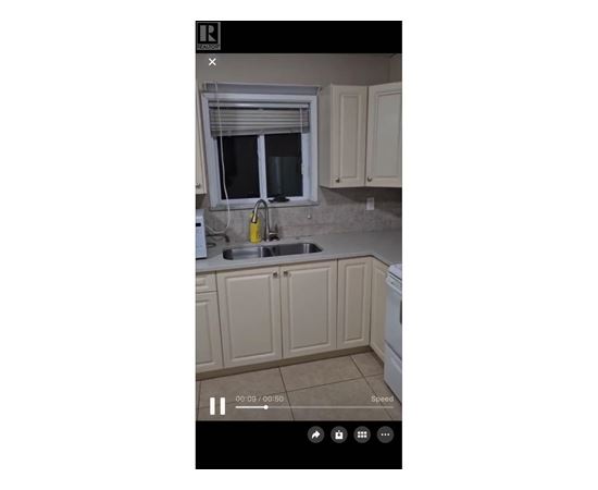 A kitchen with beige cabinets and a window above the sink.