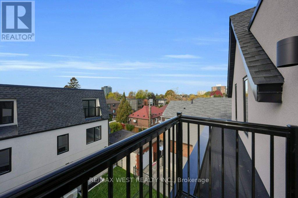 A balcony overlooks a residential area with houses and trees.