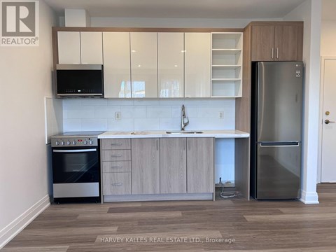 A kitchen with a stainless steel refrigerator and a microwave.