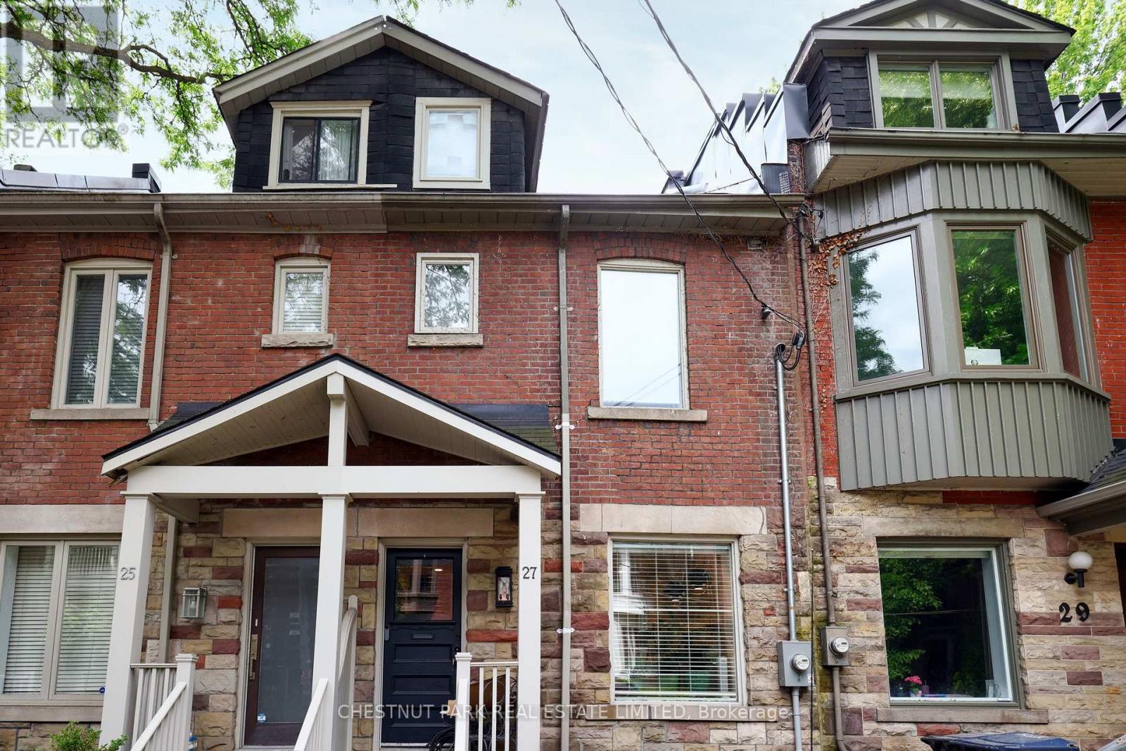 A red brick house with a black door and a sign that says "CREATURE".
