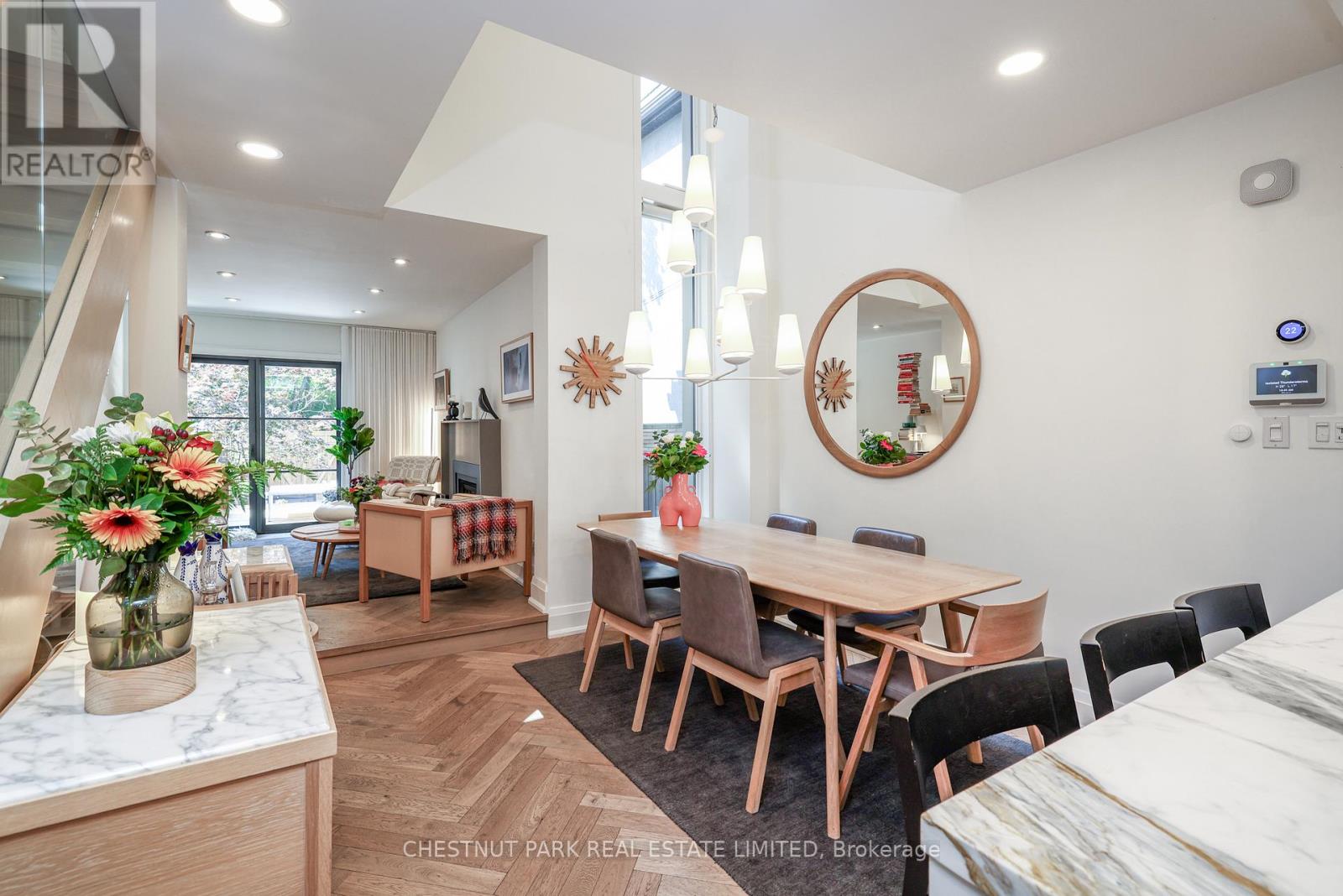 A dining room with a wooden table and chairs.