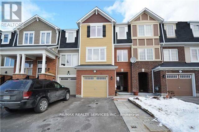 A row of houses with a car parked in front of the first one.