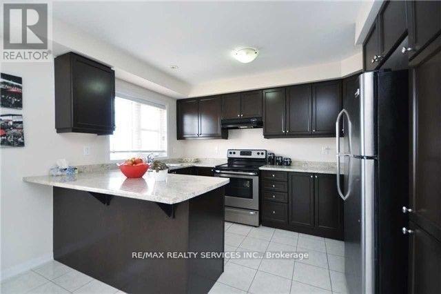 A kitchen with black cabinets and a black refrigerator.