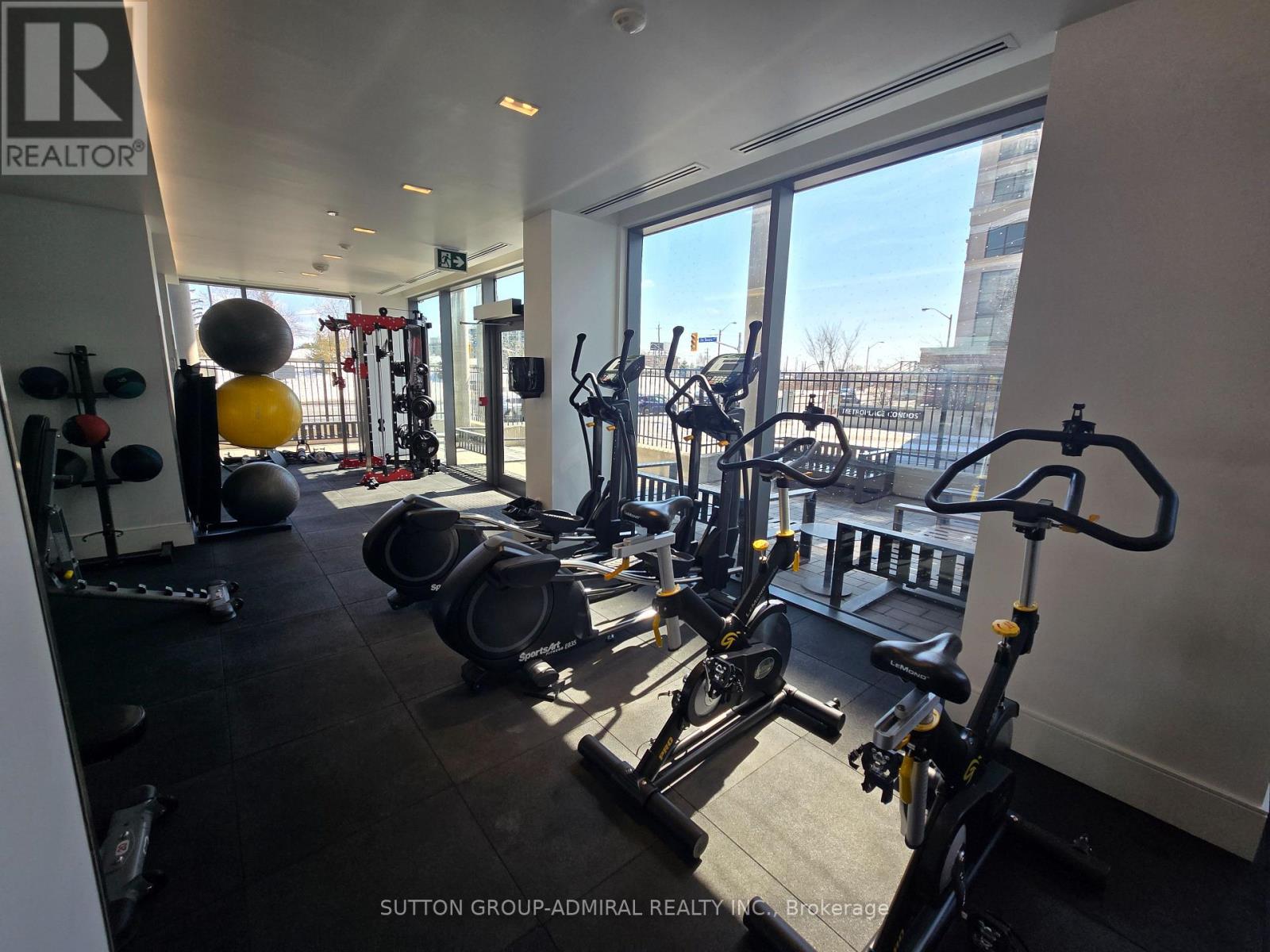 A gym with a row of stationary bikes and a variety of exercise equipment.
