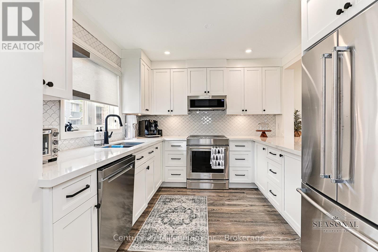 A kitchen with white cabinets and a refrigerator.