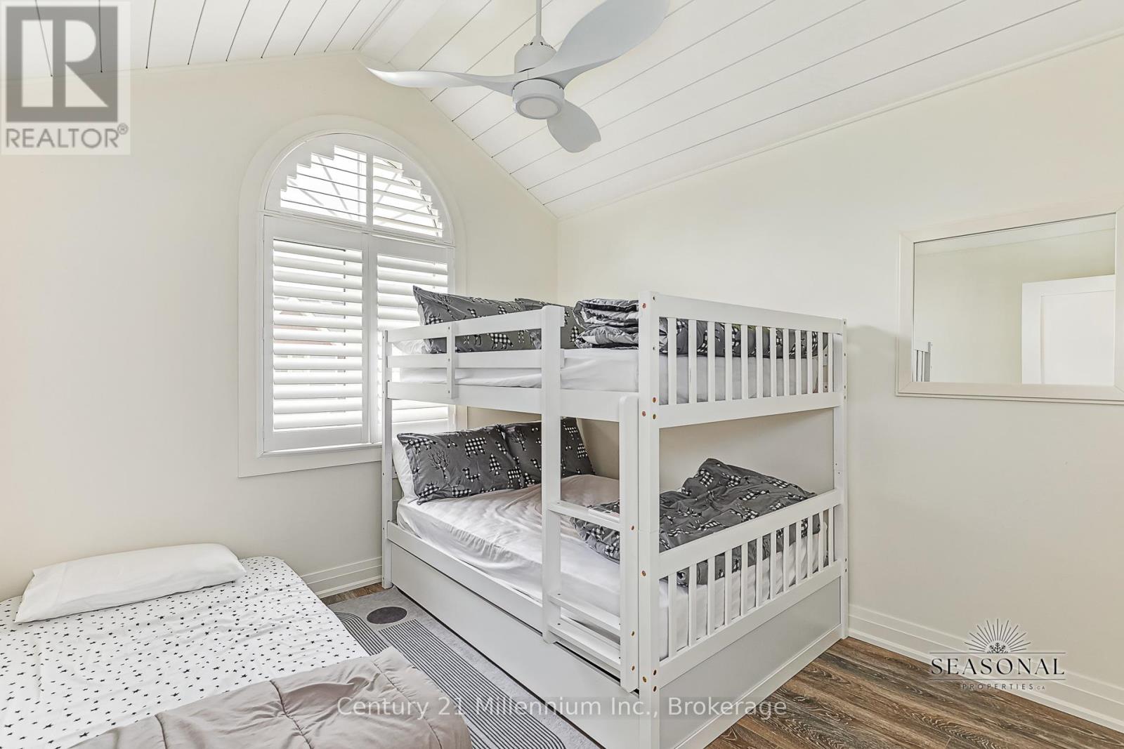 A bedroom with a bunk bed and a ceiling fan.