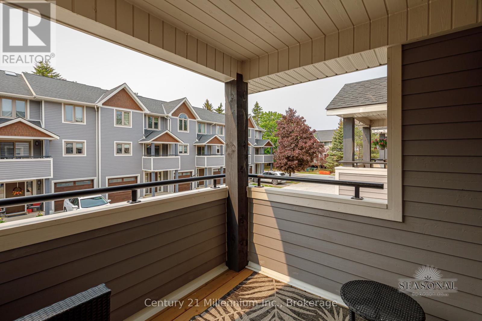 A balcony with a view of apartment buildings and a gazebo.