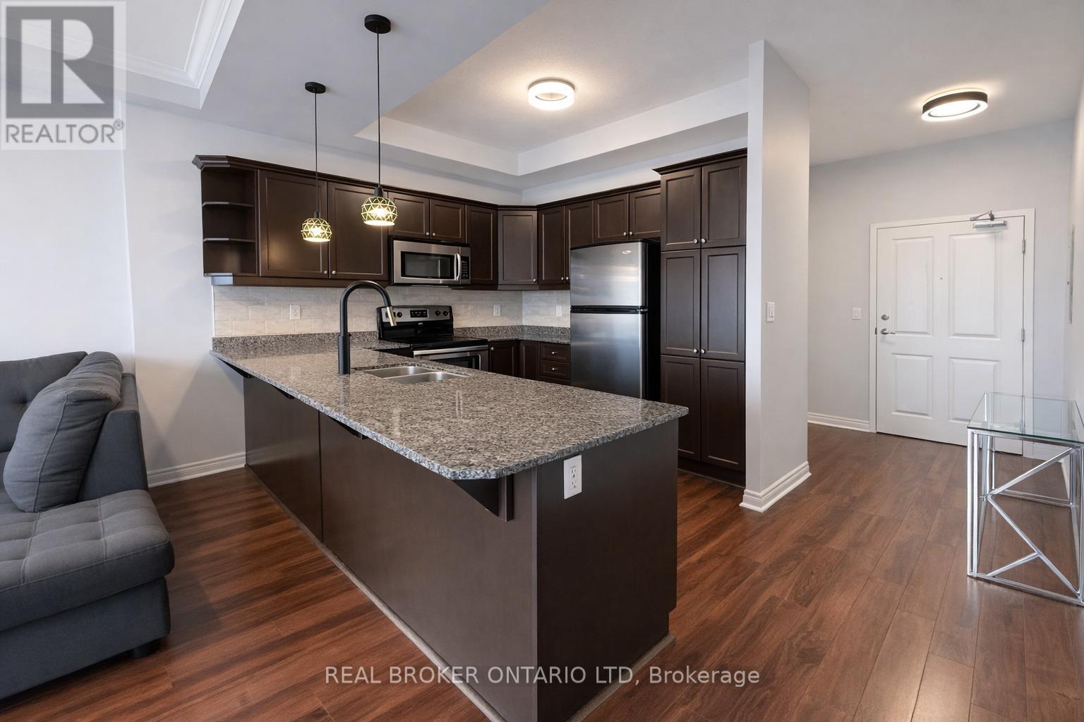 A modern kitchen with dark wood cabinets and a granite countertop.