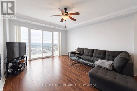 A living room with a black couch and a television.