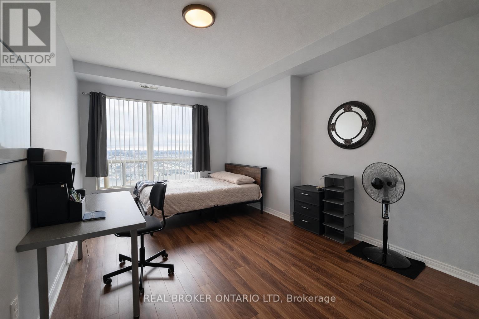 A bedroom with a bed, desk, and chair.