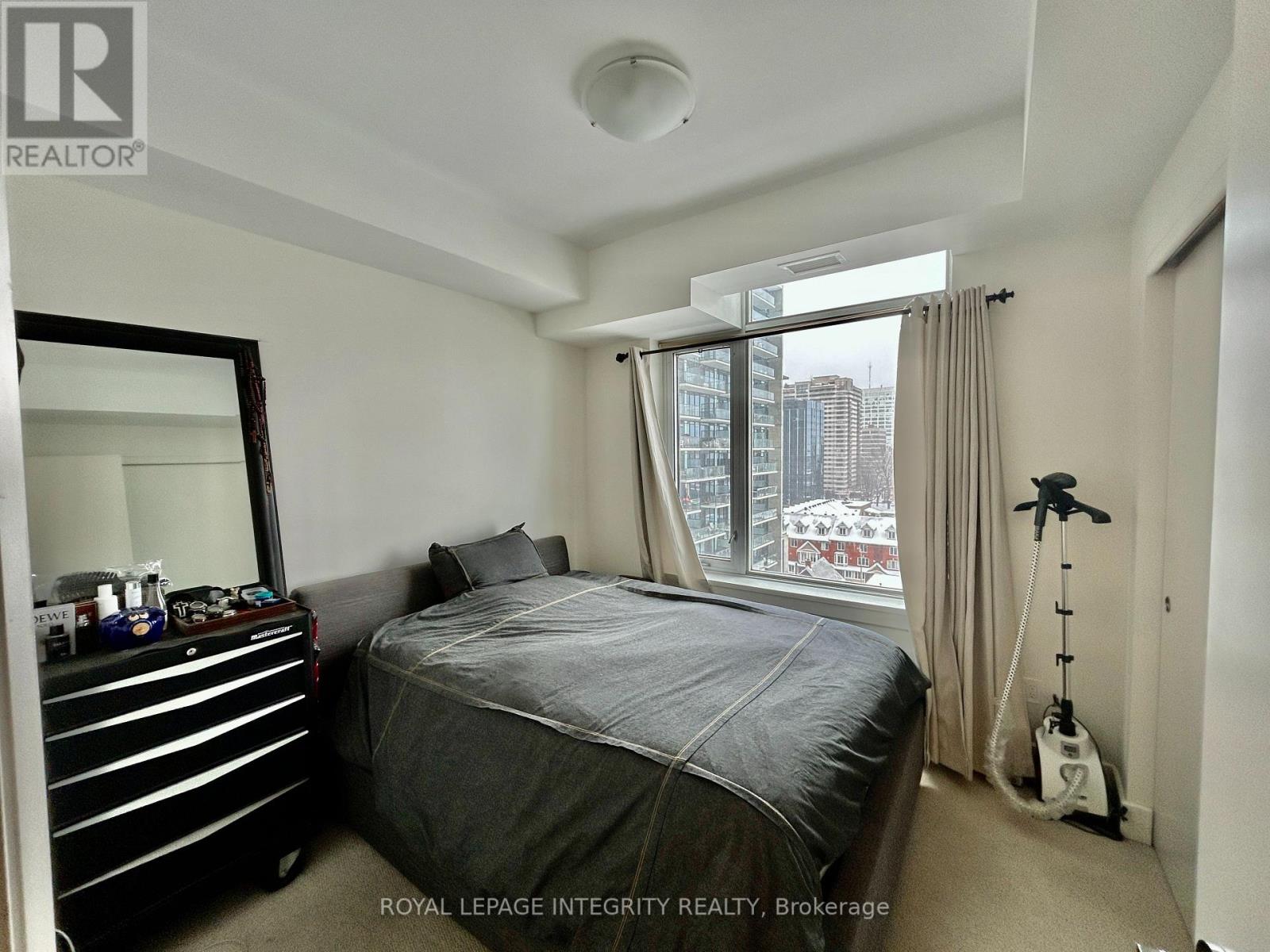 A bedroom with a large bed and a mirror on the wall.